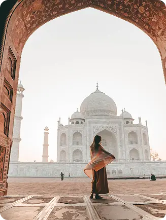 A traveller standing before the Taj Mahal archway, representing our Domestic Tour package